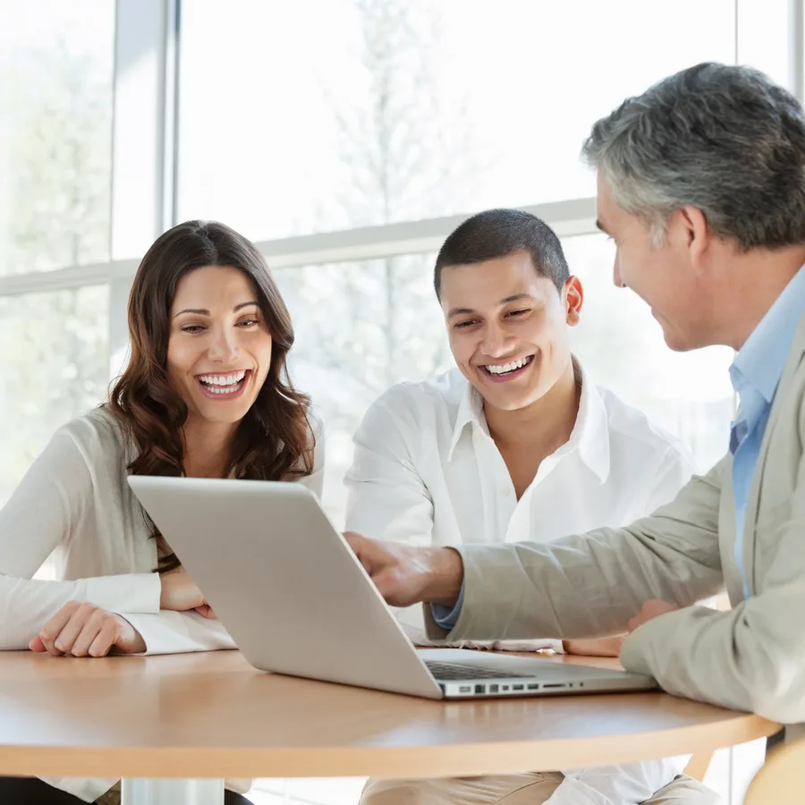 Consultant going through options on a laptop with two colleagues