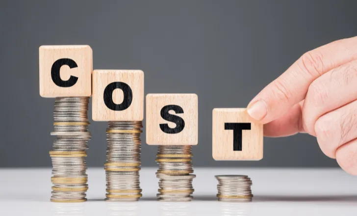 Blocks spelling COST on falling stacks of coins
