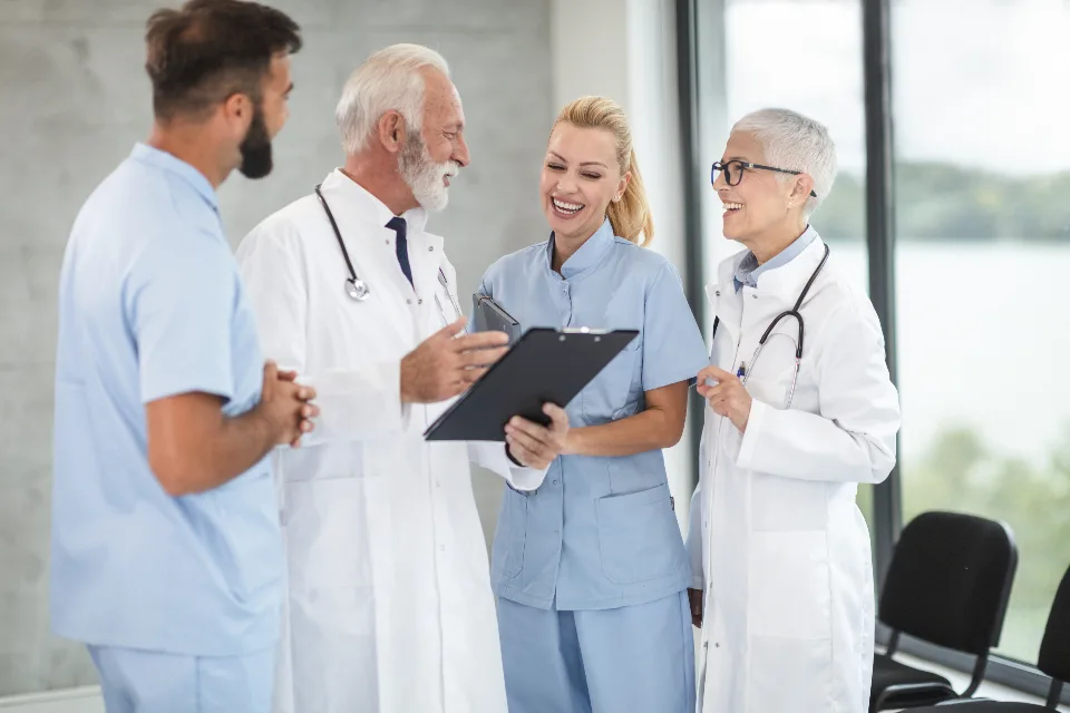 Care staff and clinicians reviewing notes together on a clipboard