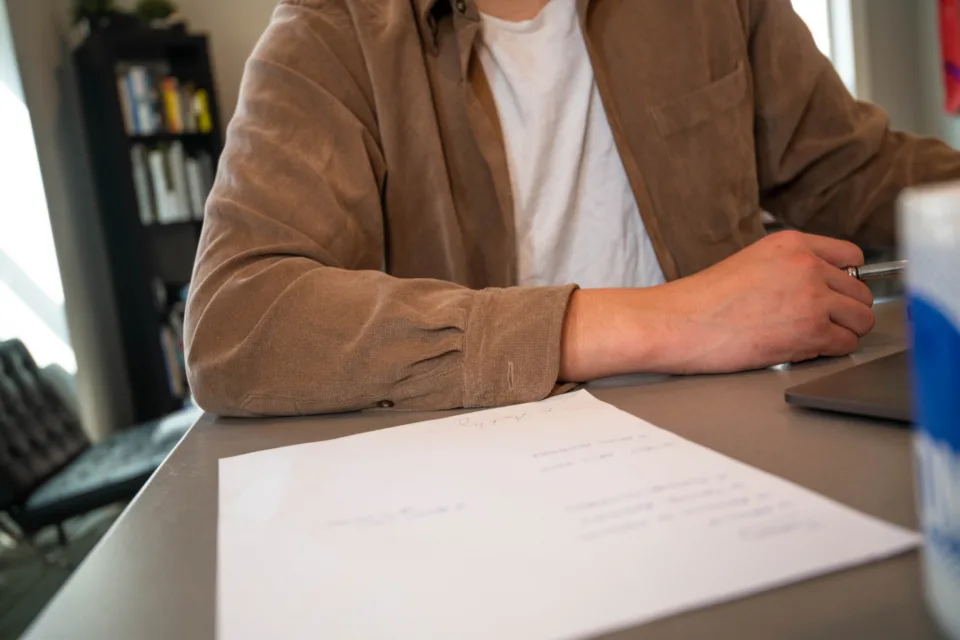 Person at a desk working through a printed document