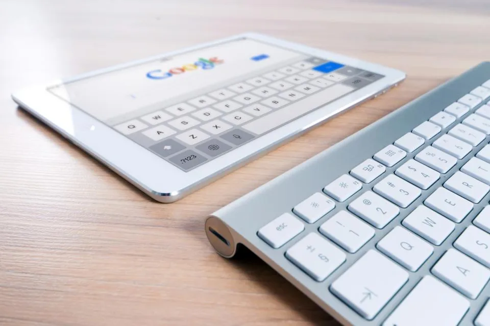 Tablet showing the Google search page beside a keyboard