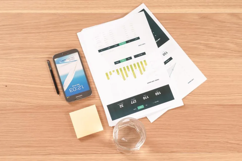 Printed charts and a phone laid out on a desk